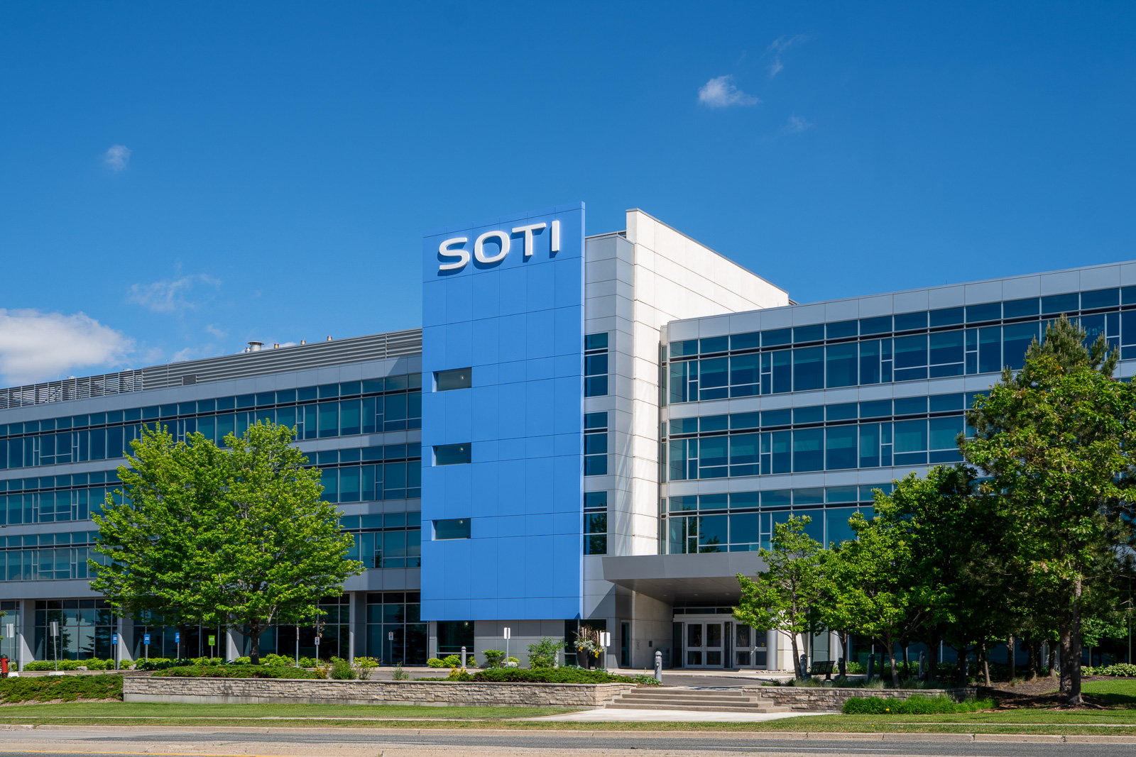 SOTI Mississauga commercial facade with blue ACM panels, glass curtain wall, and modern office building exterior.