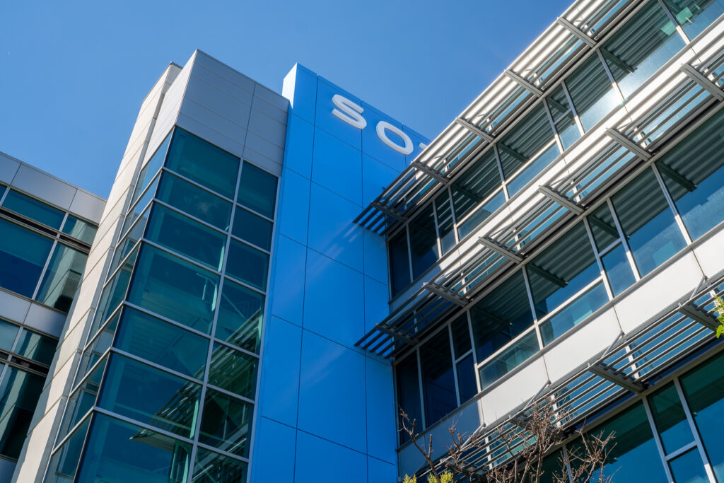 Angled view of SOTI blue ACM tower with glass facade and exterior screening system.