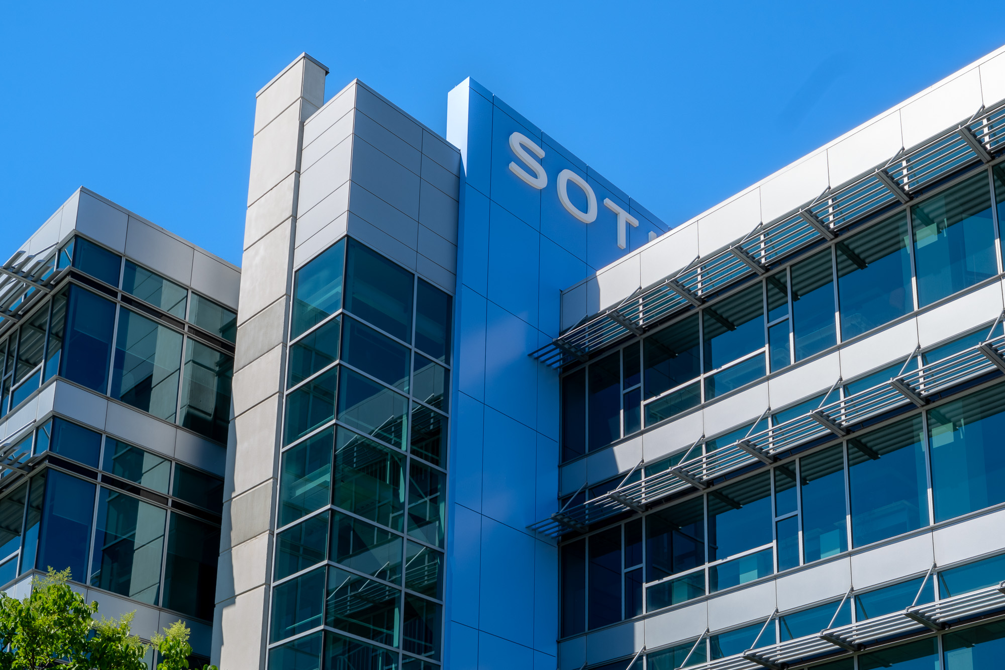 SOTI Mississauga blue ACM tower with glass curtain wall and exterior metal screening detail.
