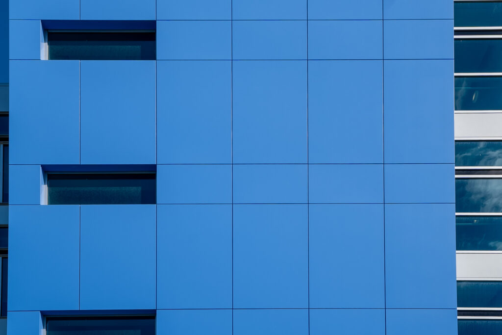 Close-up of blue ACM panel grid on SOTI tower showing clean joint lines and panel alignment.